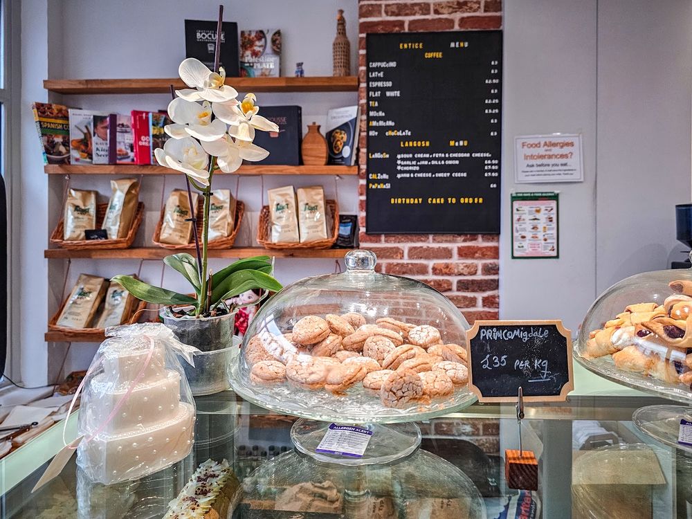 Inside the shop: shelves of coffee bags, an orchid and a dome of doughnuts against the brick wall